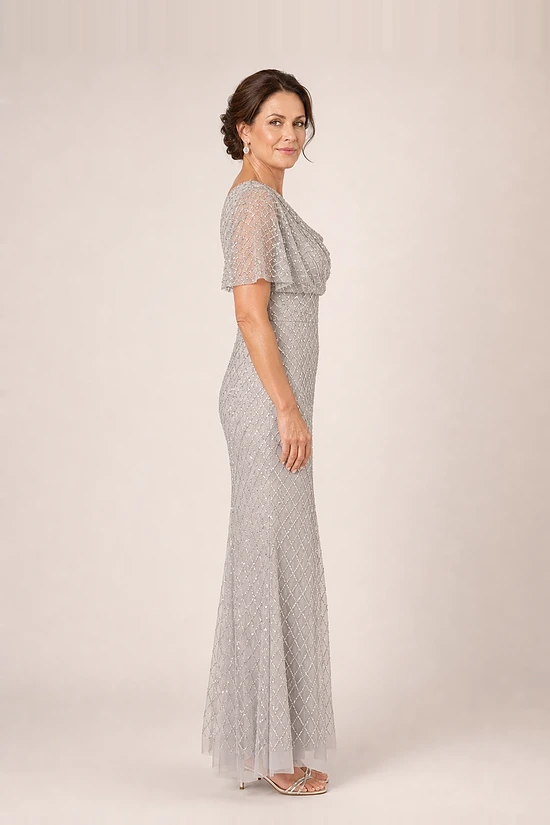 Side view of the crystal silver beaded mermaid gown showing the cowl drape and flutter sleeve