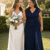 Mother of the bride wearing the navy Delphine glitter knit gown by Dressology, laughing arm in arm with her daughter the bride at a garden wedding