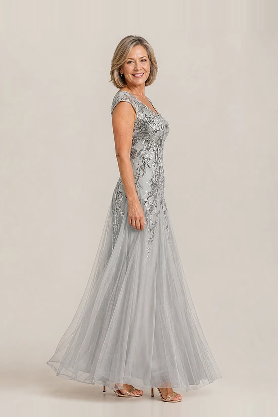 Side view of the silver glitter embroidered A-line gown showing the cap sleeve and tulle skirt