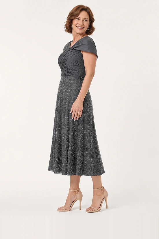 Side view of the charcoal pearl-beaded A-line midi dress showing the shoulder drape and the flare of the skirt