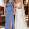 Mother and bride at a warm indoor hotel wedding, wearing Charlotte Dusty Blue gown by Dressology
