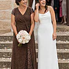 Mother of the bride wearing the chocolate brown Delphine glitter knit gown by Dressology, holding her daughter's bouquet on the church steps after the ceremony