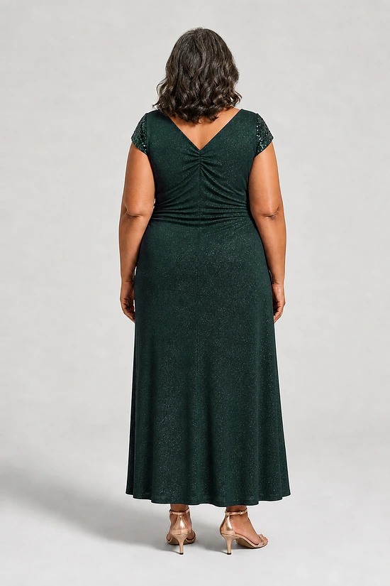 Back view of the Delphine emerald green twist-waist glitter knit gown by Dressology showing the deep V back and plain A-line skirt