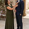 Mother of the groom wearing the olive green Delphine glitter knit gown by Dressology, straightening her son's boutonniere before the ceremony