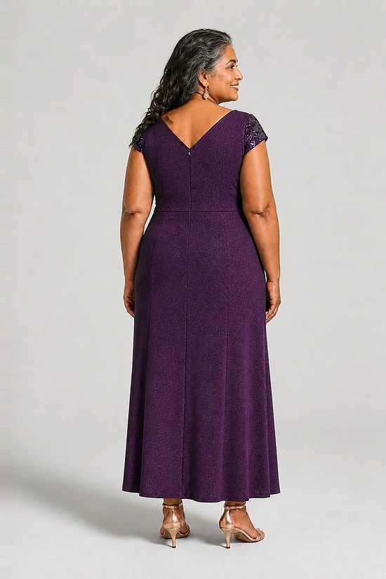 Back view of the Delphine purple twist-waist glitter knit gown by Dressology on a plus size model showing the V back and A-line skirt