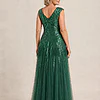 Back view of the emerald green glitter embroidered gown showing the V-shaped back and the soft trumpet tulle skirt, worn by a mother of the bride