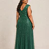 Back view of the emerald green glitter embroidered gown showing the V-shaped back and the soft trumpet tulle skirt, worn by a plus-size mother of the bride