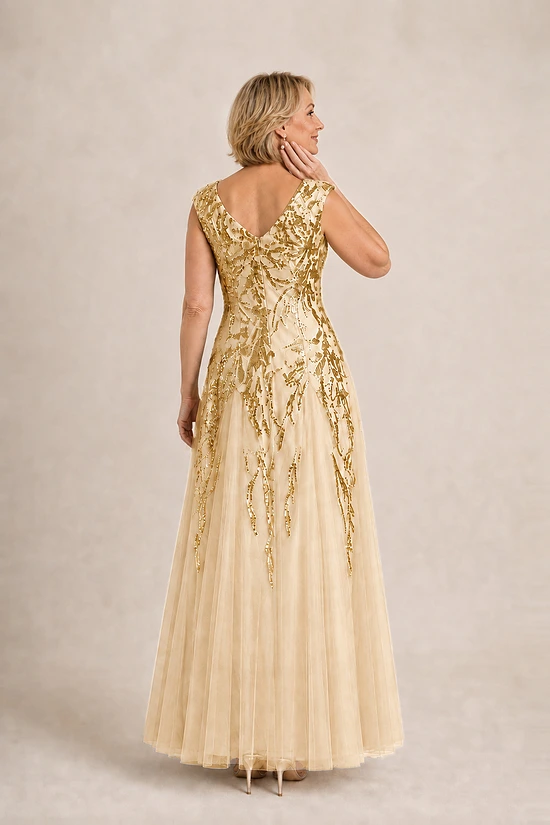 Back view of the champagne-gold Sylvie gown by Dressology showing the V-shaped back and soft trumpet skirt