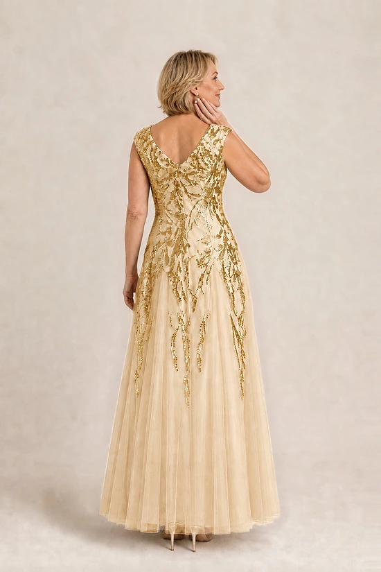 Back view of the champagne-gold Sylvie gown by Dressology showing the V-shaped back and soft trumpet skirt