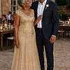 Illustrative wedding scene of a mother wearing the champagne-gold Sylvie gown with her groom son at a sandstone reception venue