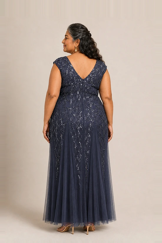 Back view of the navy glitter embroidered gown showing the V-shaped back and the soft trumpet tulle skirt, worn by a plus-size mother of the bride