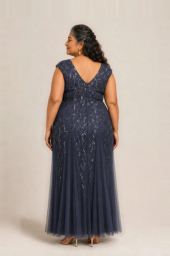 Back view of the navy glitter embroidered gown showing the V-shaped back and the soft trumpet tulle skirt, worn by a plus-size mother of the bride