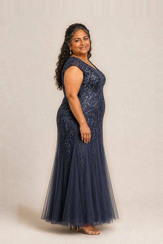 Side view of the navy glitter embroidered gown showing the cap sleeve and the soft trumpet tulle skirt, worn by a plus-size mother of the bride