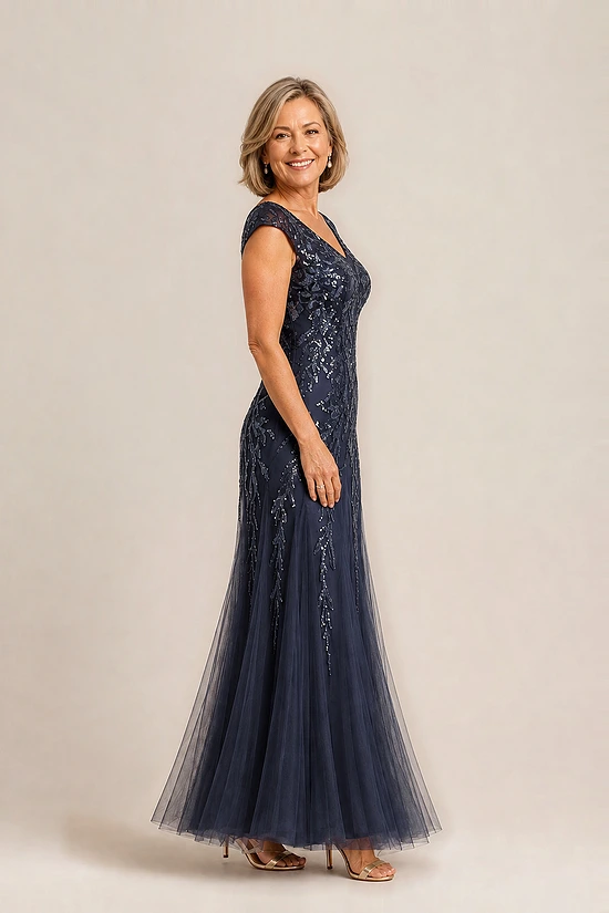 Side view of the navy glitter embroidered gown showing the cap sleeve and the soft trumpet tulle skirt, worn by a mother of the bride
